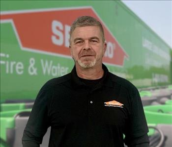 SERVPRO team member in front of new background image