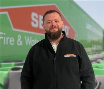 SERVPRO team member in front of new background image