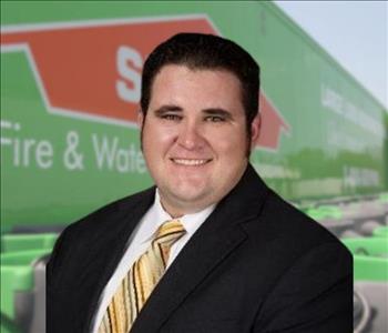 SERVPRO team member in front of new background image