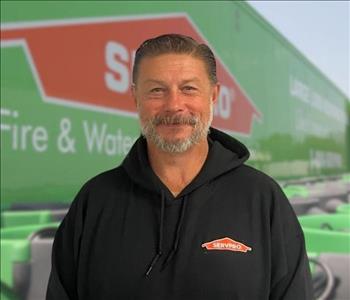 SERVPRO team member in front of new background image