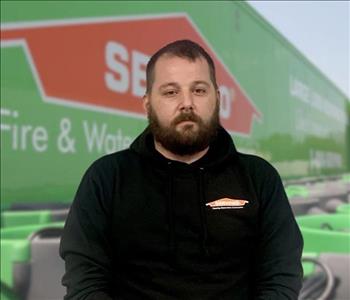 SERVPRO team member in front of new background image