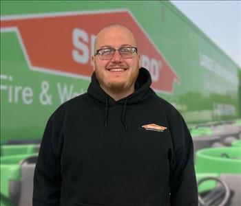 SERVPRO team member in front of new background image