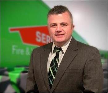 SERVPRO team member in front of new background image