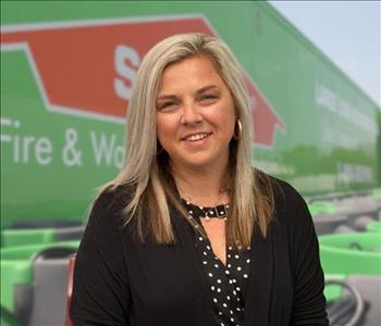 SERVPRO team member in front of new background image