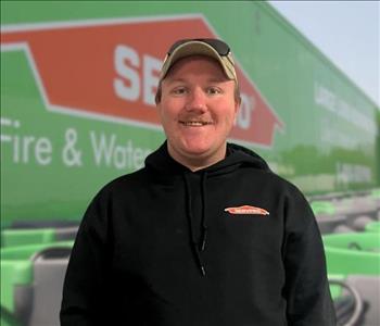 SERVPRO team member in front of new background image