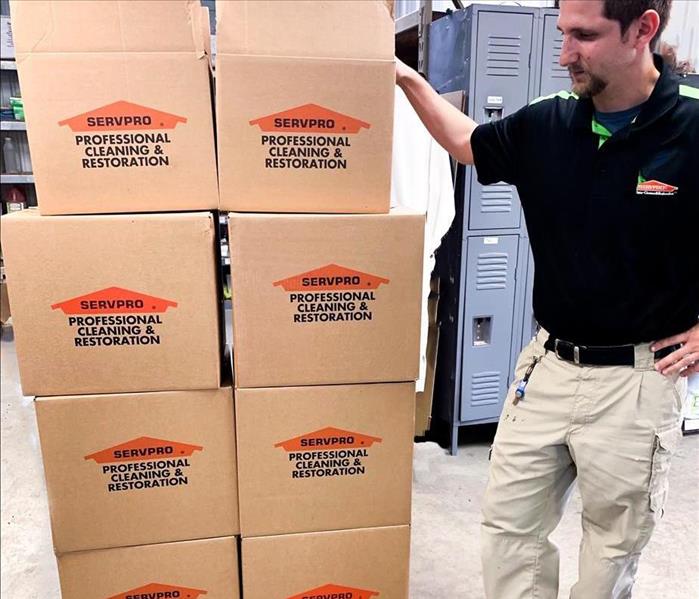 SERVPRO employeestanding by a stack of SERVPRO boxes